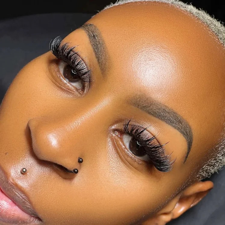 Professional brow and lash artistry showcasing perfect eyebrows and dramatic eyelash extensions